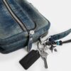 Dakota crossbody-taske i regenerativ bomuldsdenim med vedhæng