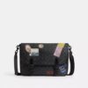 Hitch-messengertaske i Signature Canvas med patches