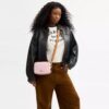 Mini Carey-crossbody-taske i Signature Canvas med Vedhæng