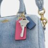Mini Rowan crossbody-taske i slidt denim med vedhæng