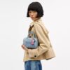 Mini Rowan crossbody-taske i slidt denim med vedhæng